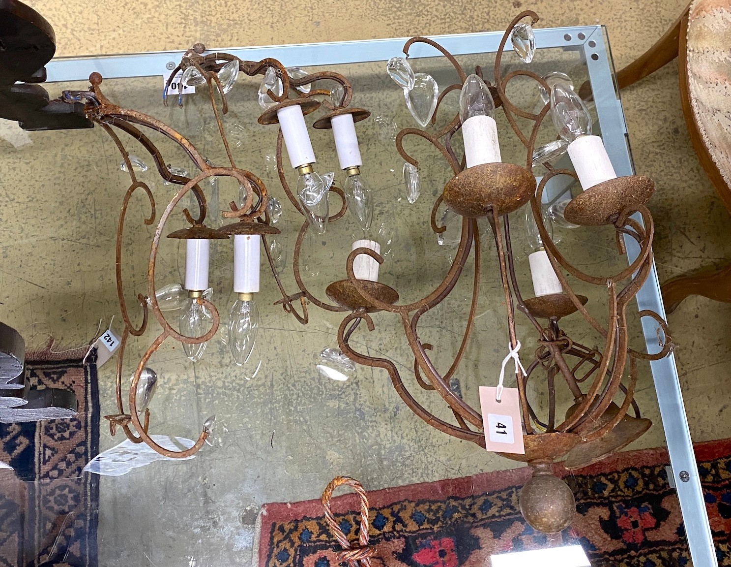 A wrought iron four branch ceiling light, hung oval glass drops, height 56cm together with a pair of matching two branch wall lights